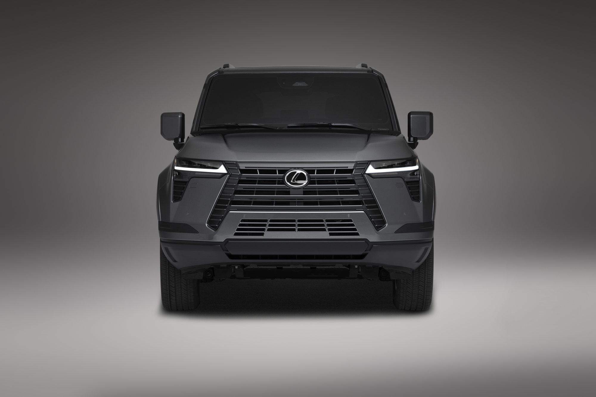 Lexus GX in dark gray, head-on view against a plain studio background
