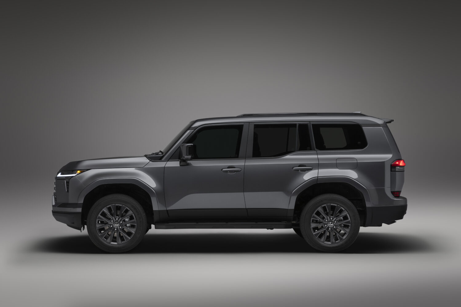 Lexus GX in gray, side profile against a dark studio background