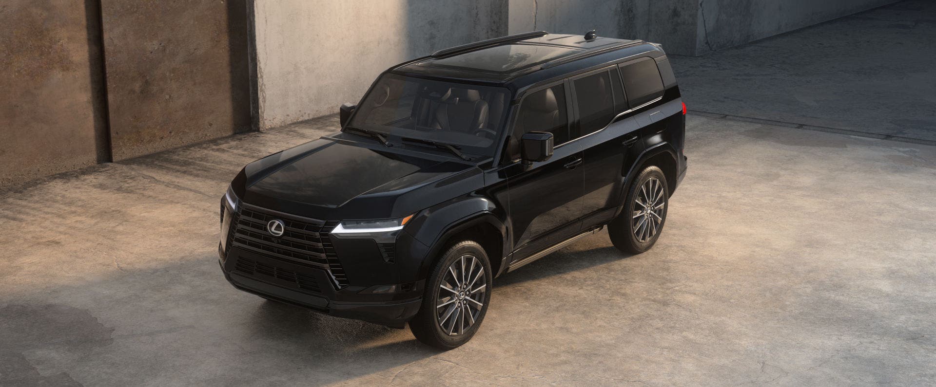 Lexus GX in black parked against a bare concrete wall