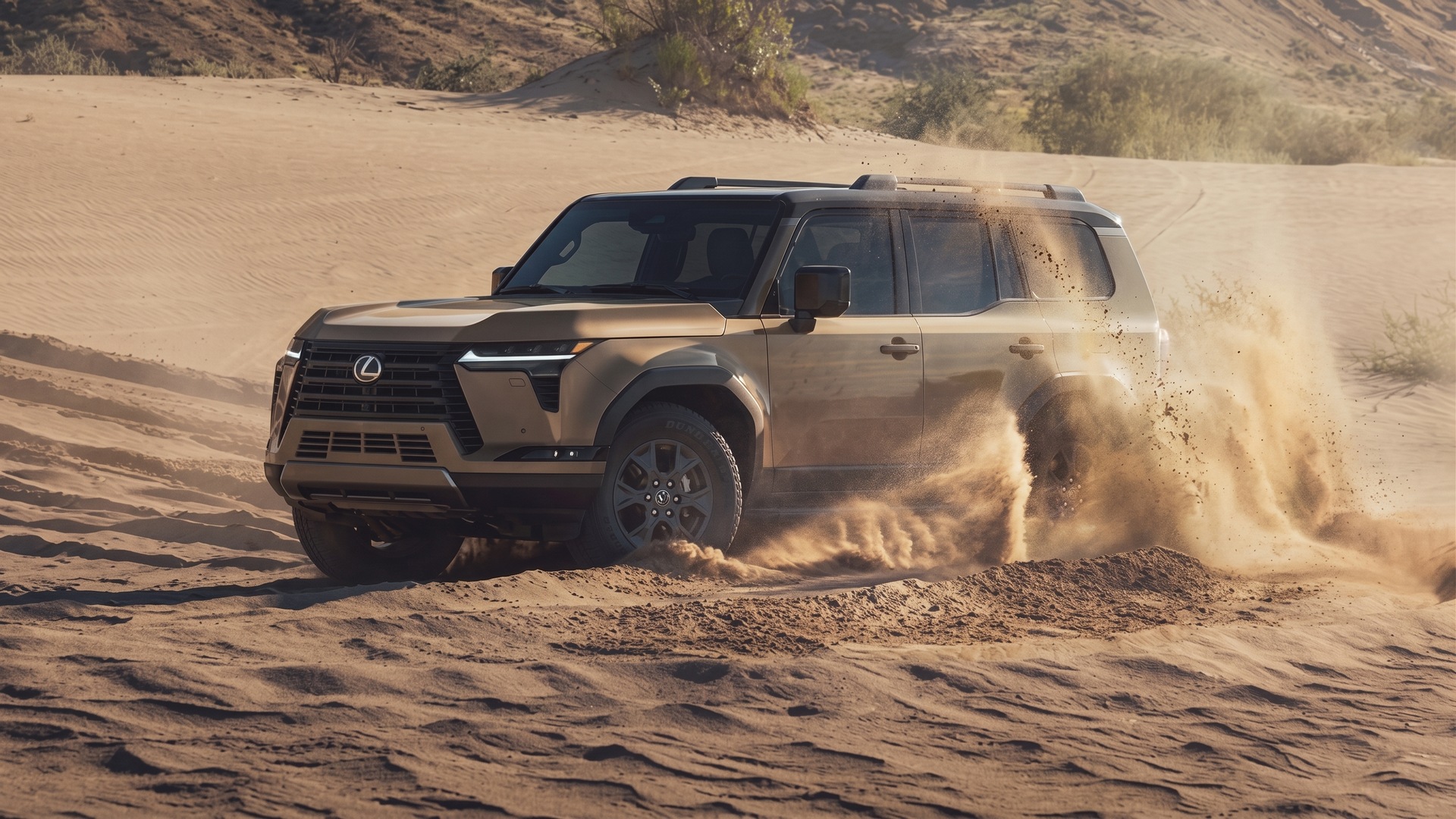 A sand-beige Lexus GX Overtrail throwing up sand as it drives across a dune