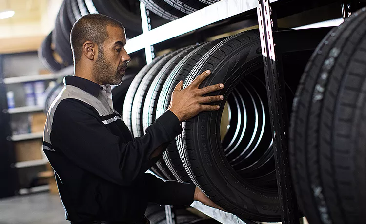 Lexus technician selecting a tire from the parts rack
