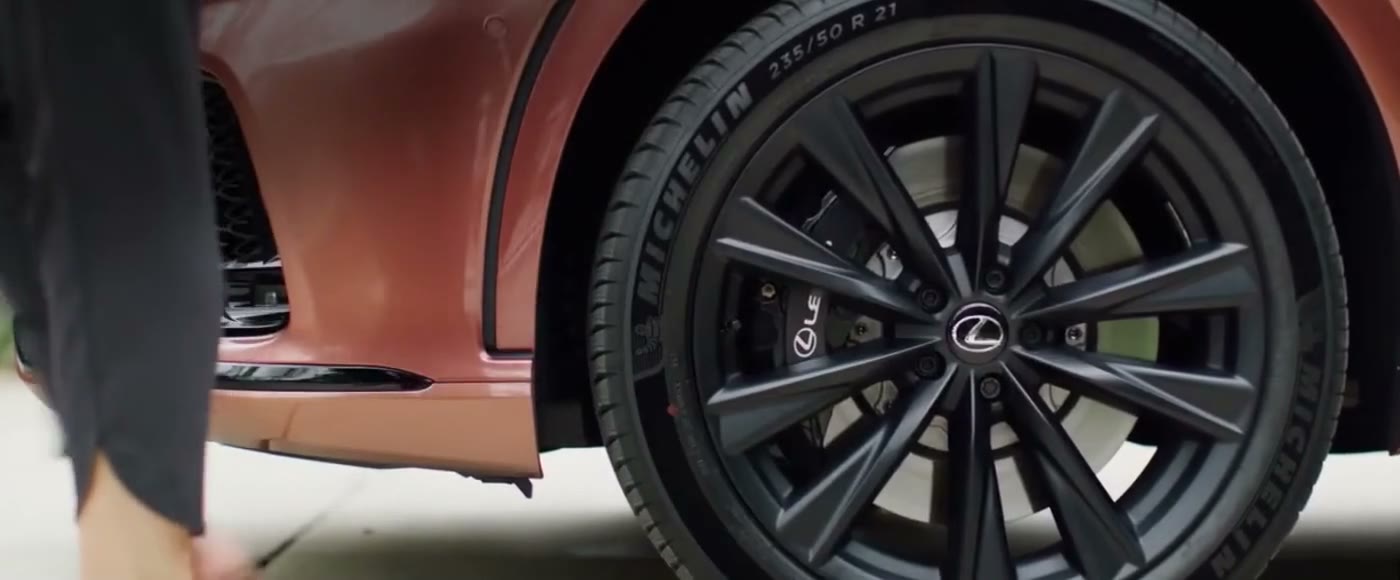 A Lexus wheel and brake caliper, with an owner beside the car