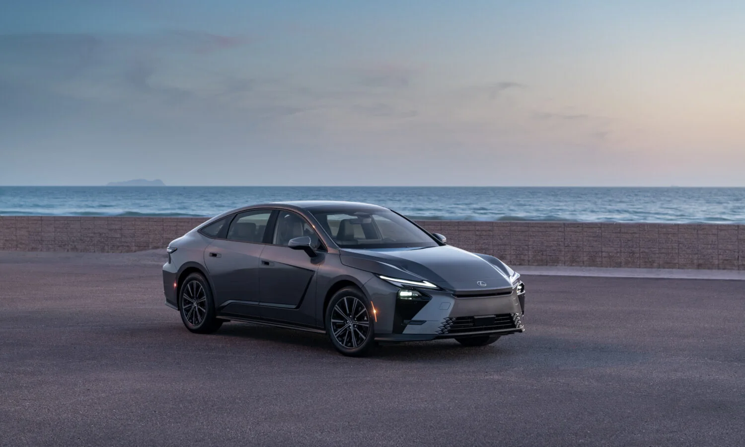 Lexus ES 350h in Cloudburst Gray parked on the coast at dusk