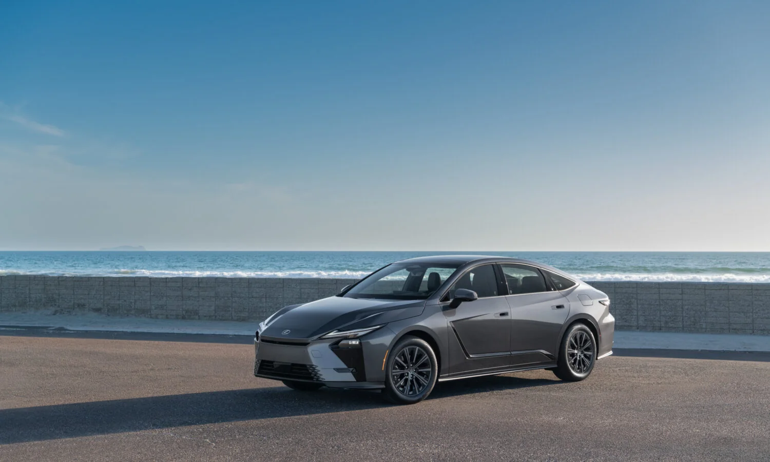 Lexus ES 350h in Cloudburst Gray, front three-quarter view with the ocean behind