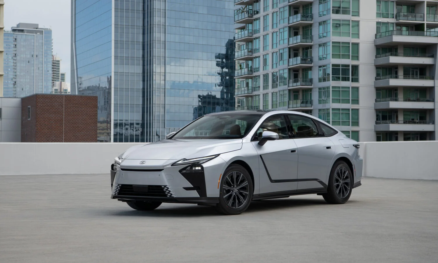 Lexus ES 350h in Iridium silver, front three-quarter view against a city skyline