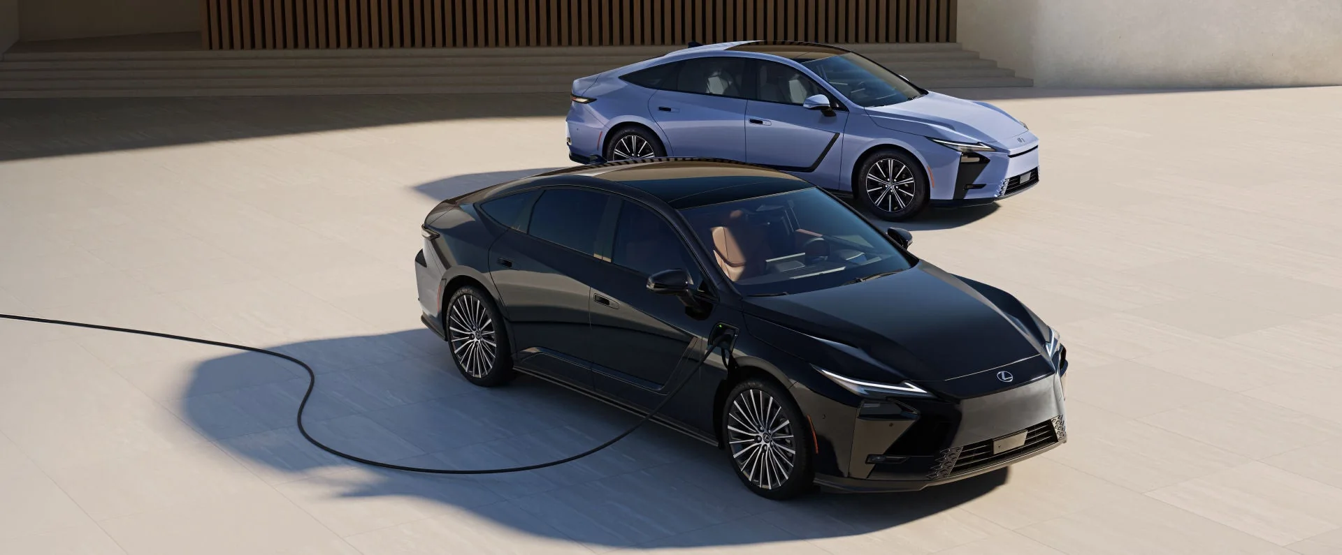 Two Lexus ES sedans in a pale stone plaza, the black one plugged in to charge