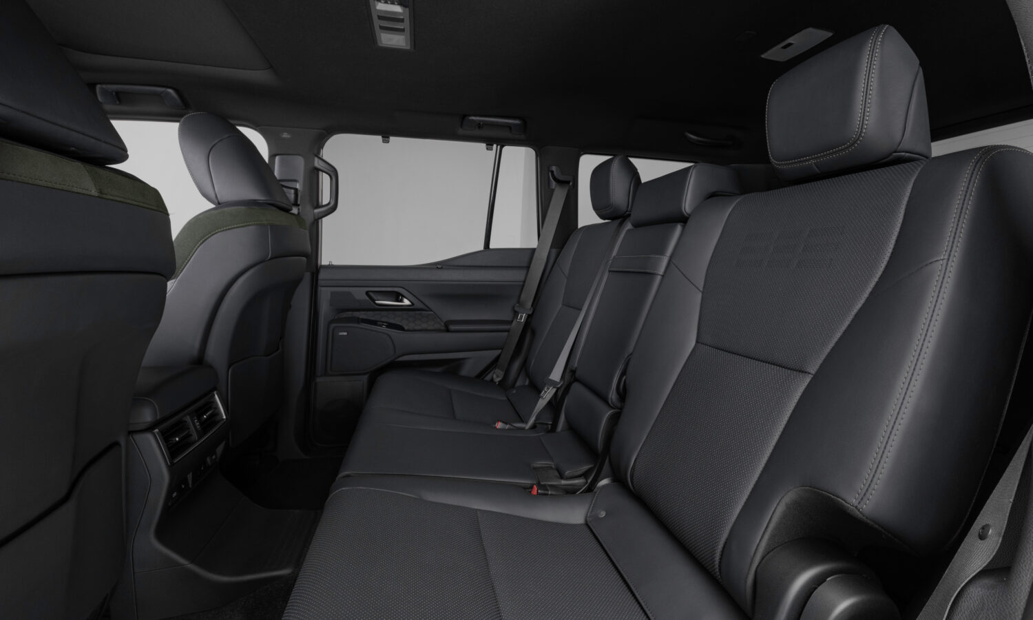 The second-row seats of a Lexus GX Overtrail in black leather, seen through the open rear door
