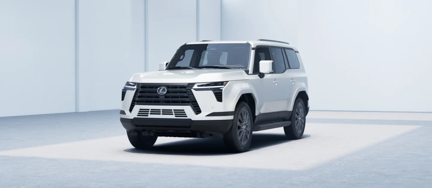 Lexus GX in white, front three-quarter view showing the spindle grille