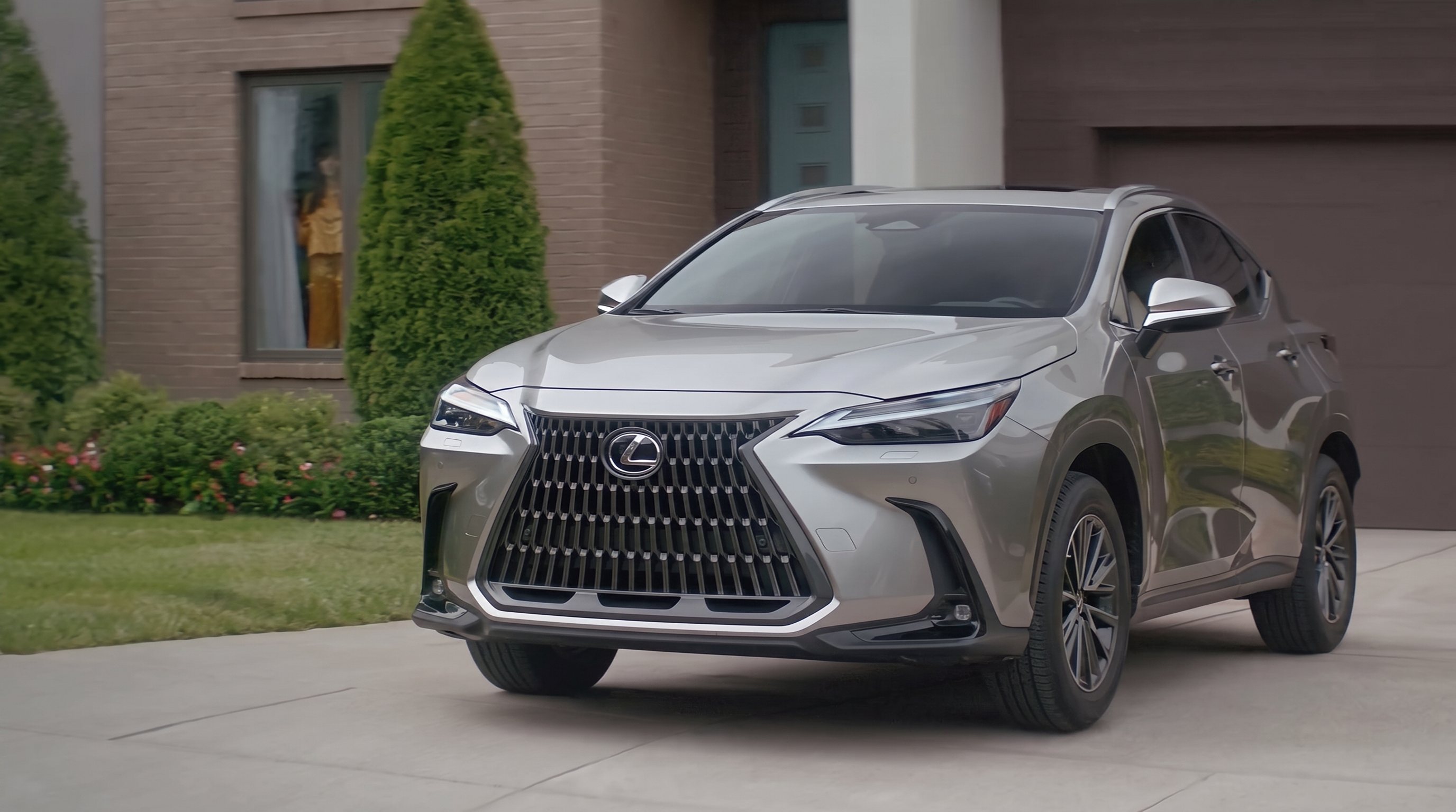 Lexus NX in silver parked on the driveway of a suburban home
