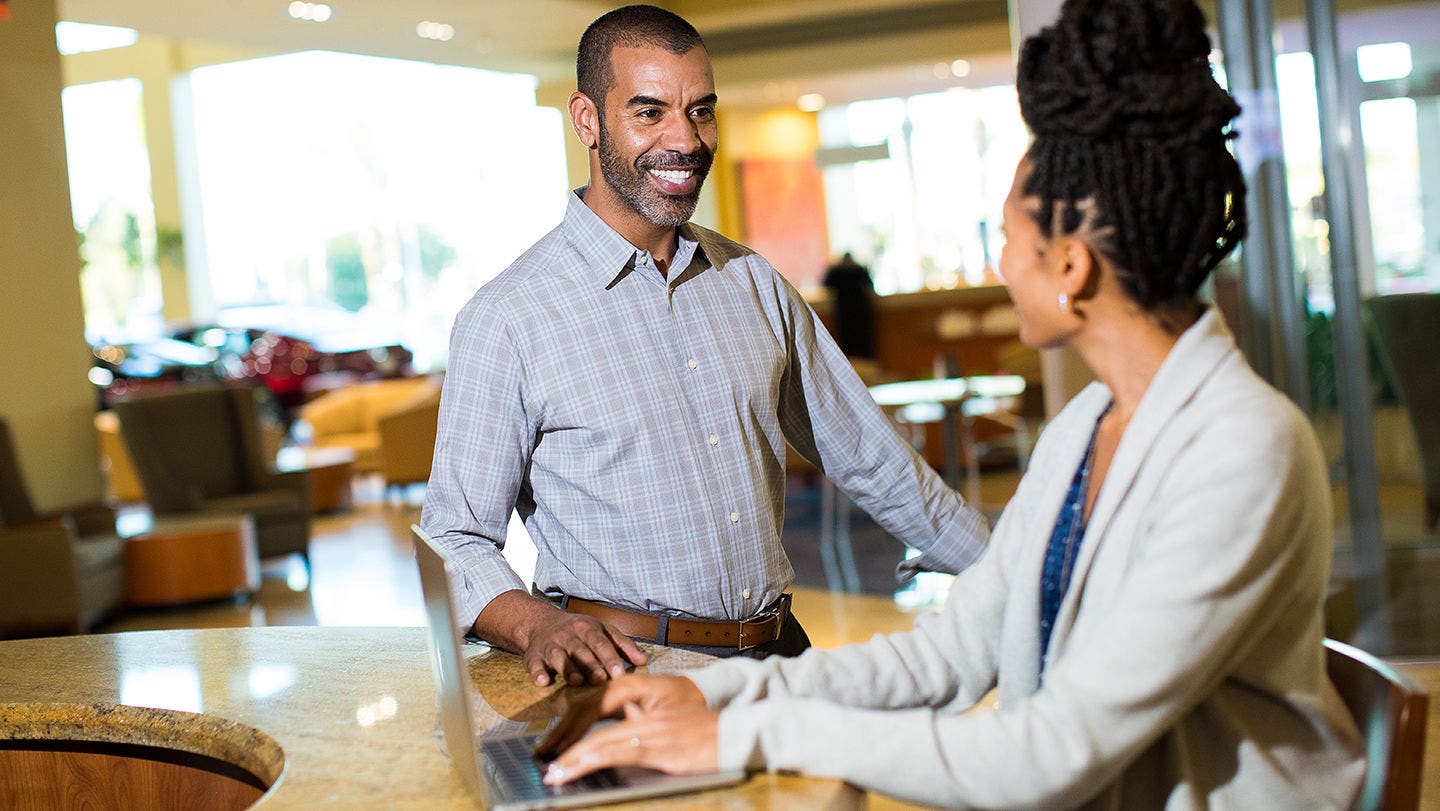 Lexus service advisor going through paperwork with a customer at the counter