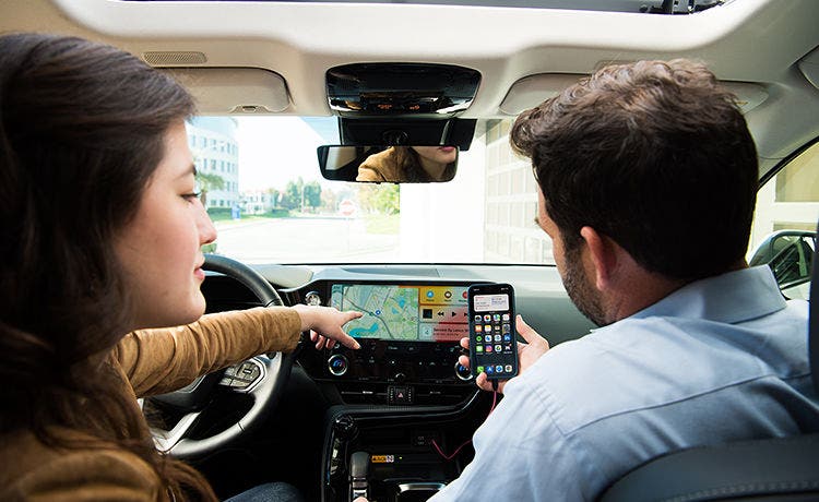 Two people going through the vehicle's service information on the dashboard screen