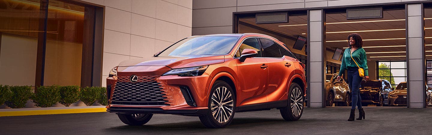 Lexus RX in copper pulling up to the open service entrance as an advisor comes out