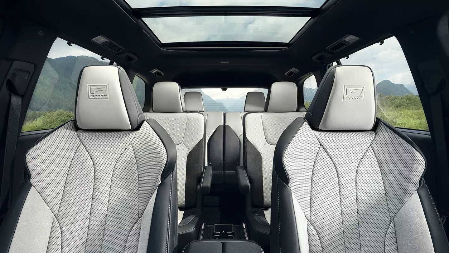 The interior of a Lexus TX looking back through three rows, with captain's chairs in the second row and a panoramic roof
