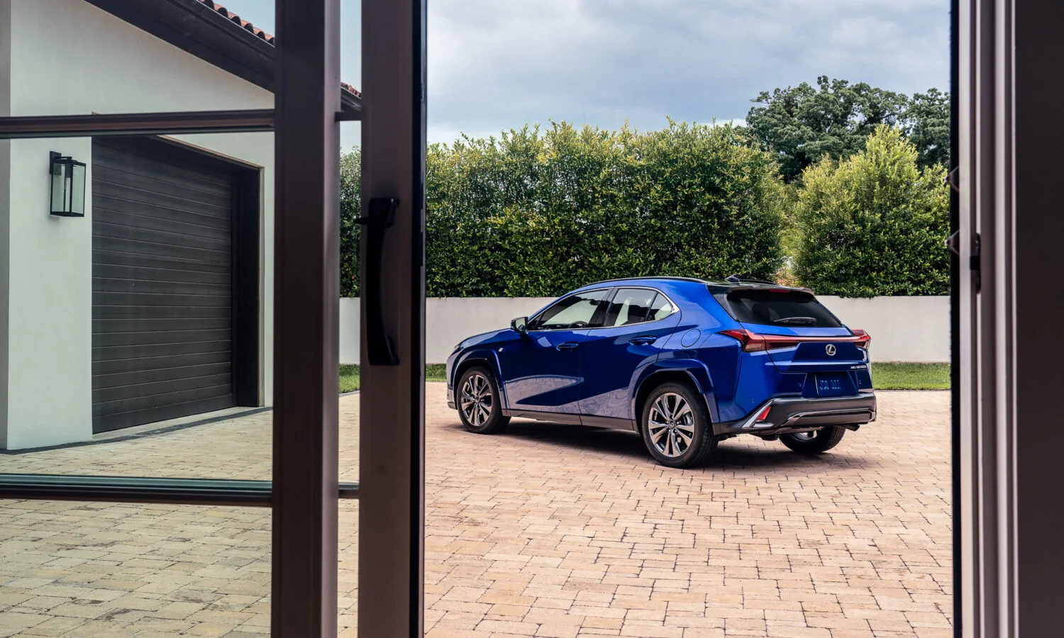 Lexus UX 300h F SPORT in blue seen through an open doorway