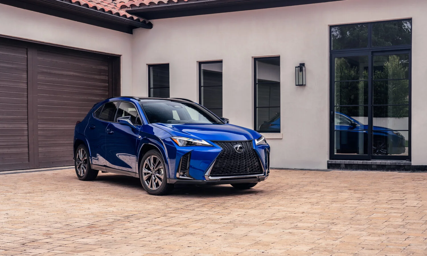 Lexus UX 300h F SPORT in blue parked in front of a garage