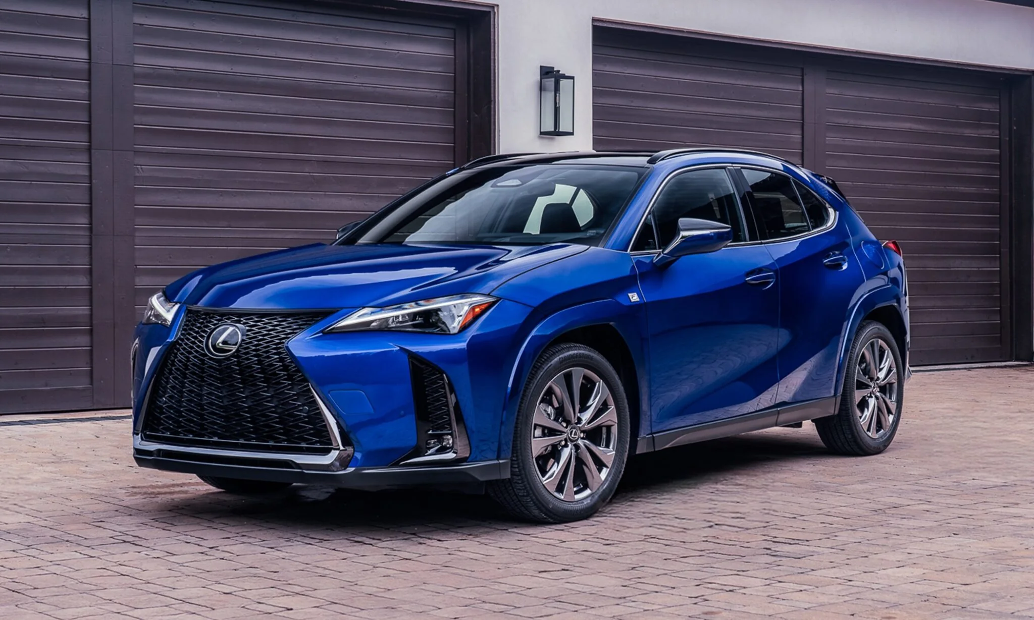 Lexus UX 300h F SPORT in blue, front three-quarter view on a brick driveway