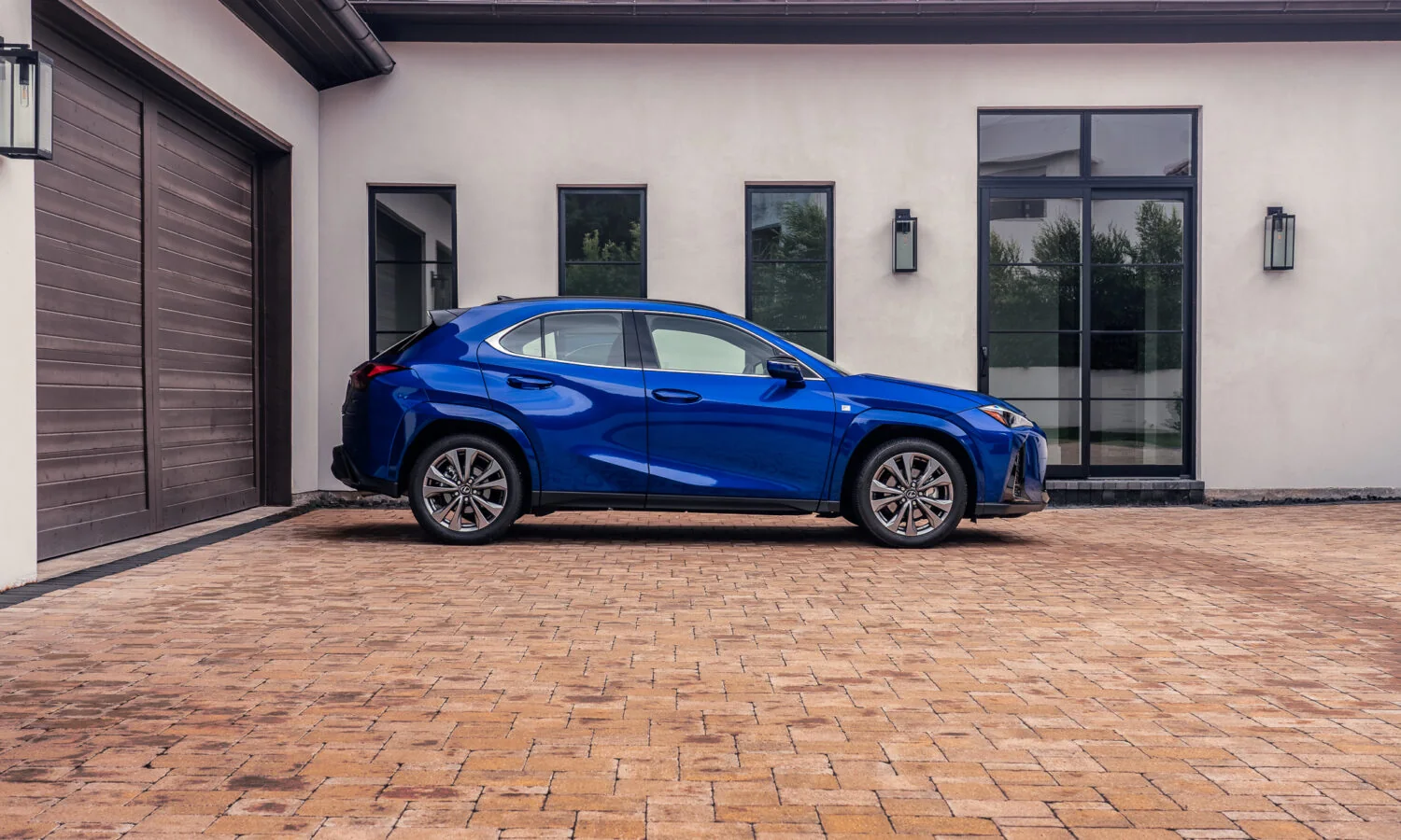 Lexus UX 300h F SPORT in blue, rear three-quarter view in a courtyard